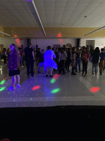 Students dancing under colorful lights at an A.L. Stanback school dance